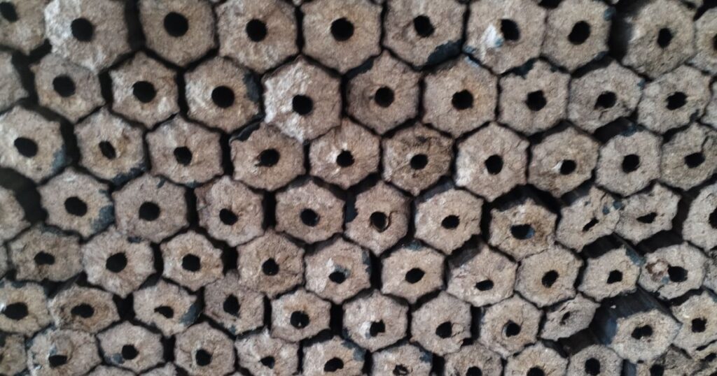 Close-up of stacked hexagonal sawdust wood briquettes for industry