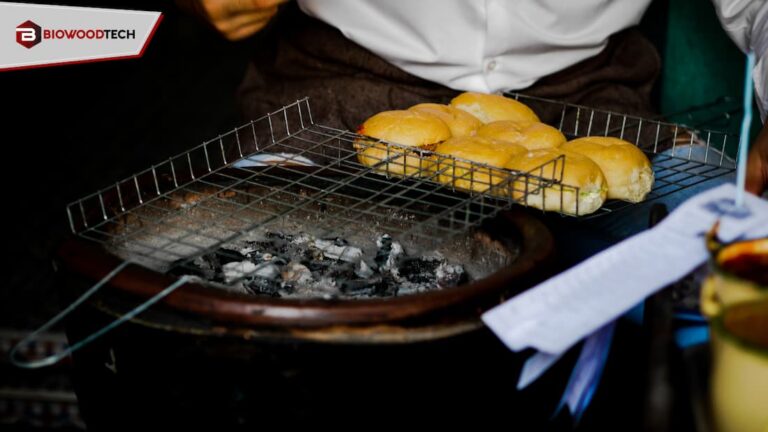 A professional charcoal grill with glowing embers and a wire rack holding buns, showcasing Biowoodtech’s premium restaurant-grade charcoal in a commercial food setting.